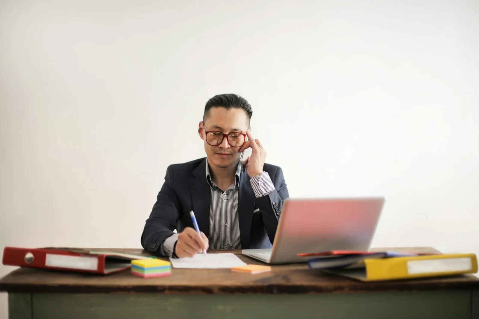 Consultant on phone call taking notes at desk