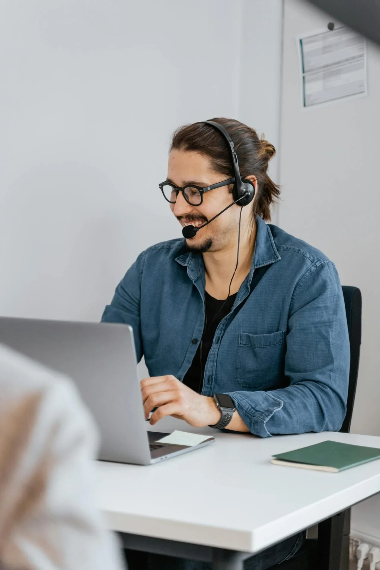Customer support rep with headset at desk